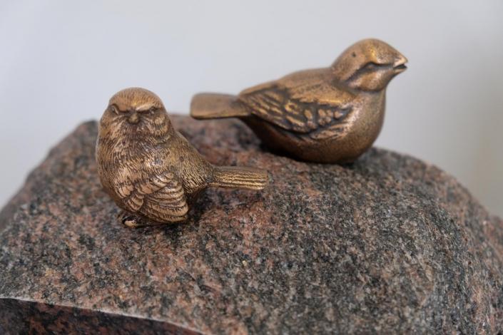 Bronzene Vögel auf einem Stein
